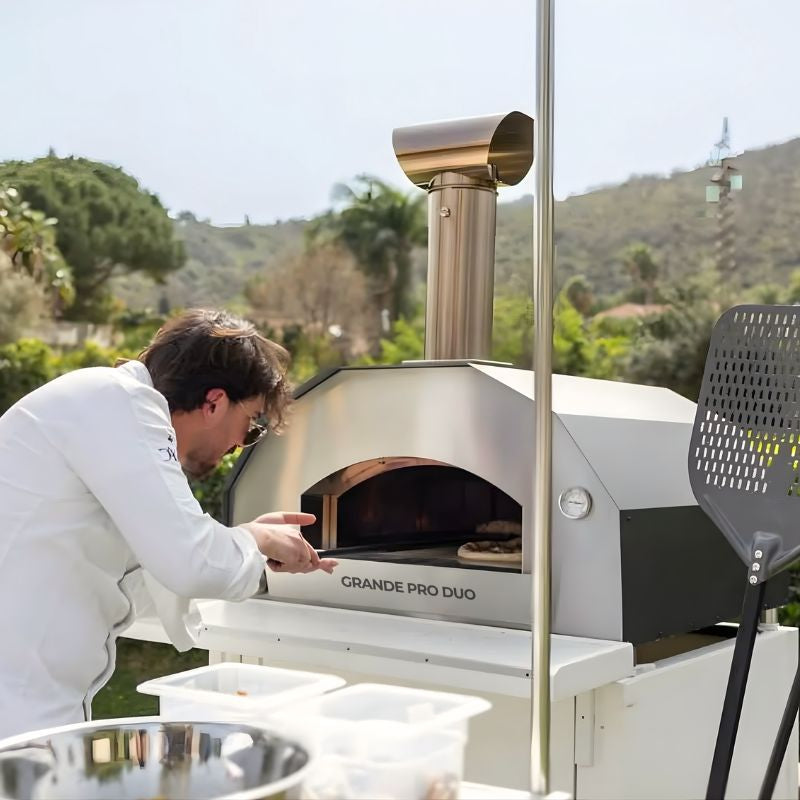 Chef baking a pizza in the Italia Forno Grande Pro Duo Hybrid Pizza oven