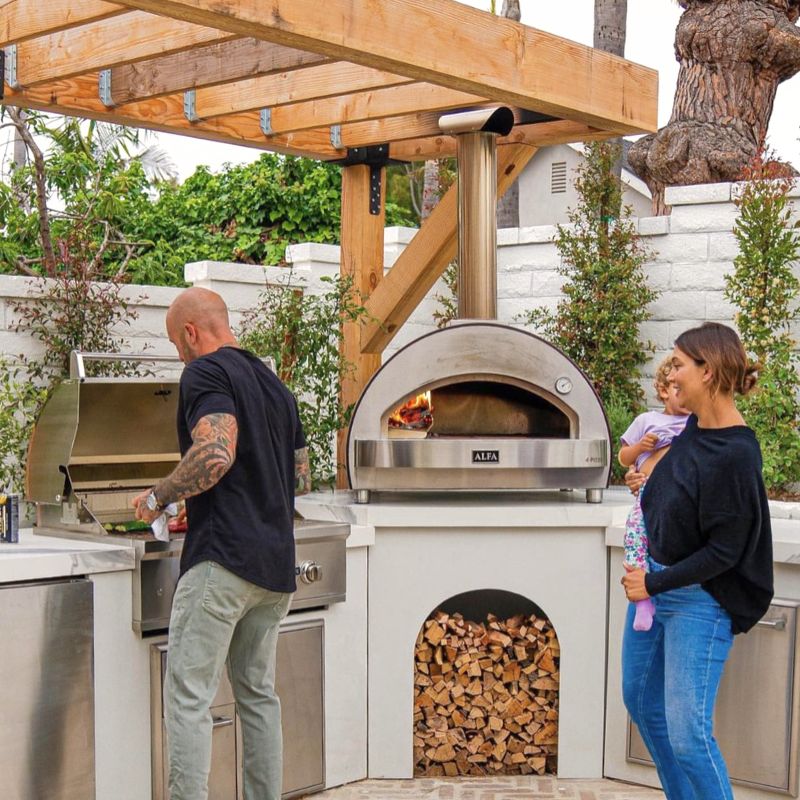 Family using the Alfa 4 Pizze Countertop pizza oven in a backyard setting | Large outdoor oven
