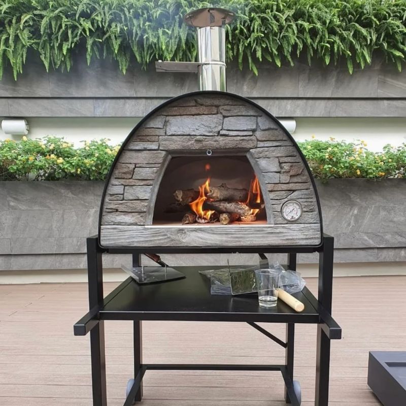 Firewood logs stacked inside to pre-heat the Maximus oven