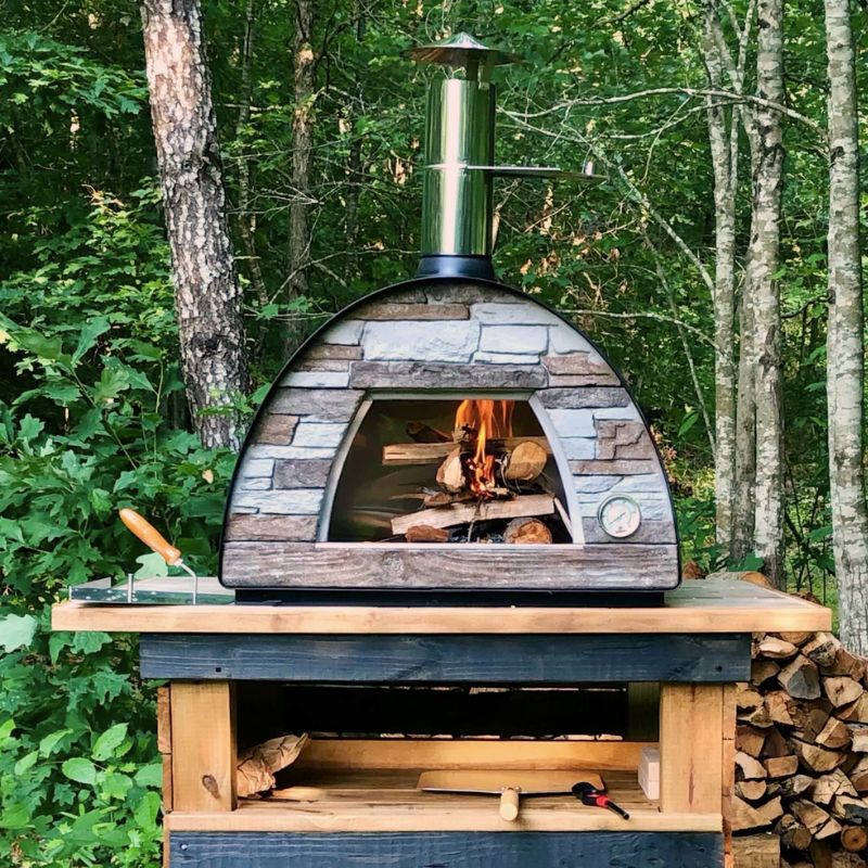 Maximus Arena Pizza Oven in the woods and on a custom made wood stand