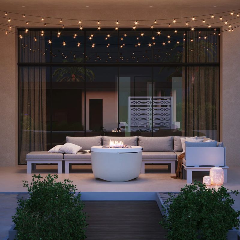 Outdoor sofa set surrounding the Ledge Halo Firepit on a backyard patio