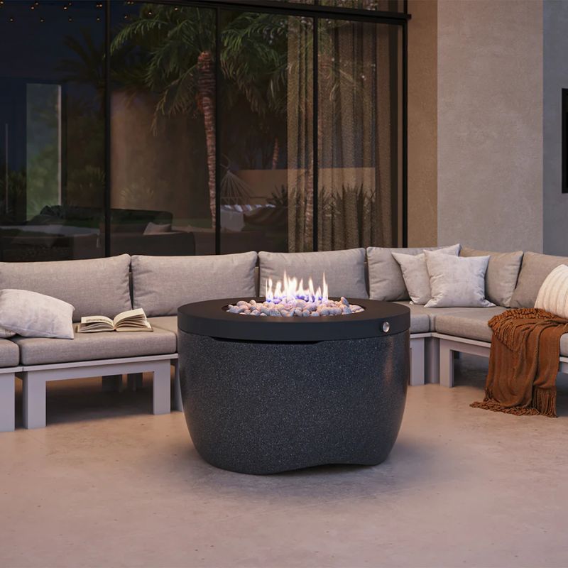 Patio seating around the Ledge Halo Firepit outdoor propane fire table in color Nightfall
