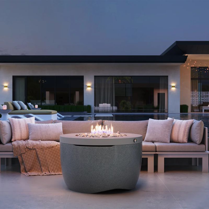 Outdoor sofa set surrounding the Ledge Halo Firepit in color Twilight on a backyard patio