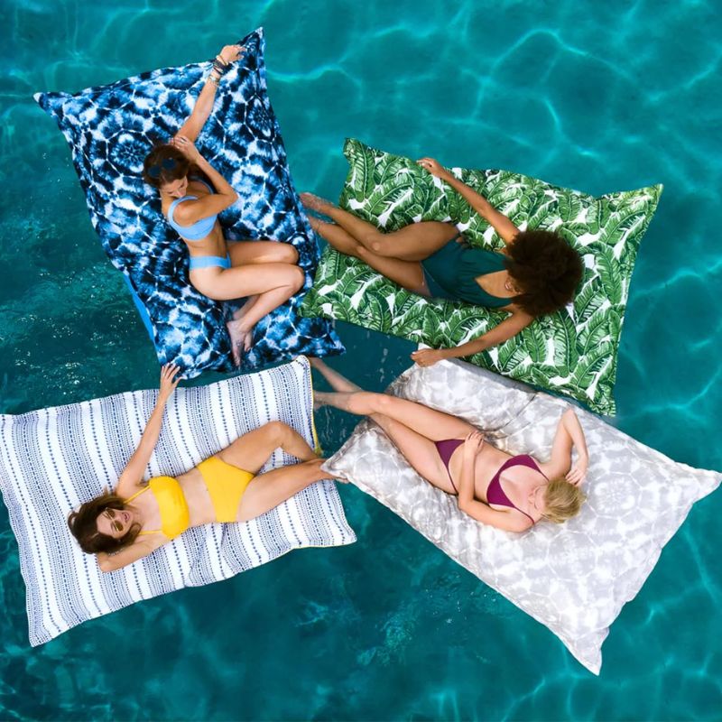 Friends floating on the luxury pool pillow by Ledge