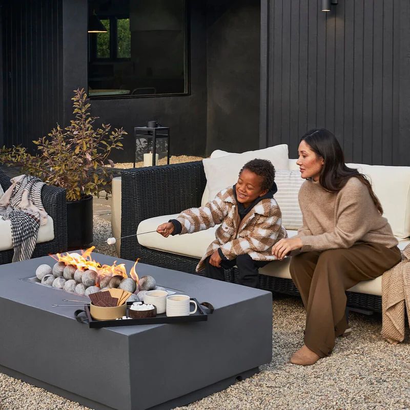 Mom and son making s'mores on the concrete fire pit table