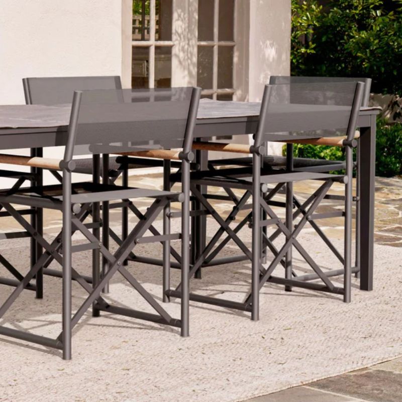 OuterShell keeping the aluminum dining table dry and clean and paired with the director's chairs in a modern patio
