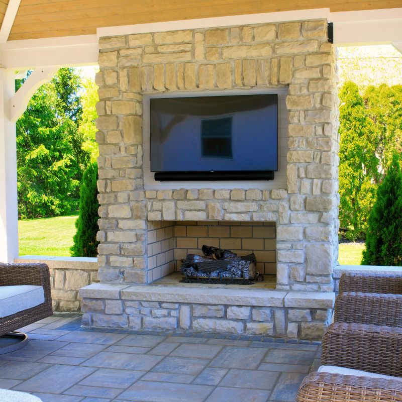 Round grove boxed shoulder fireplace with TV installed