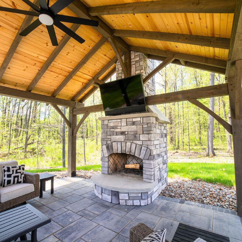 Round Grove Fireplace with Arched Firebox Opening and TV