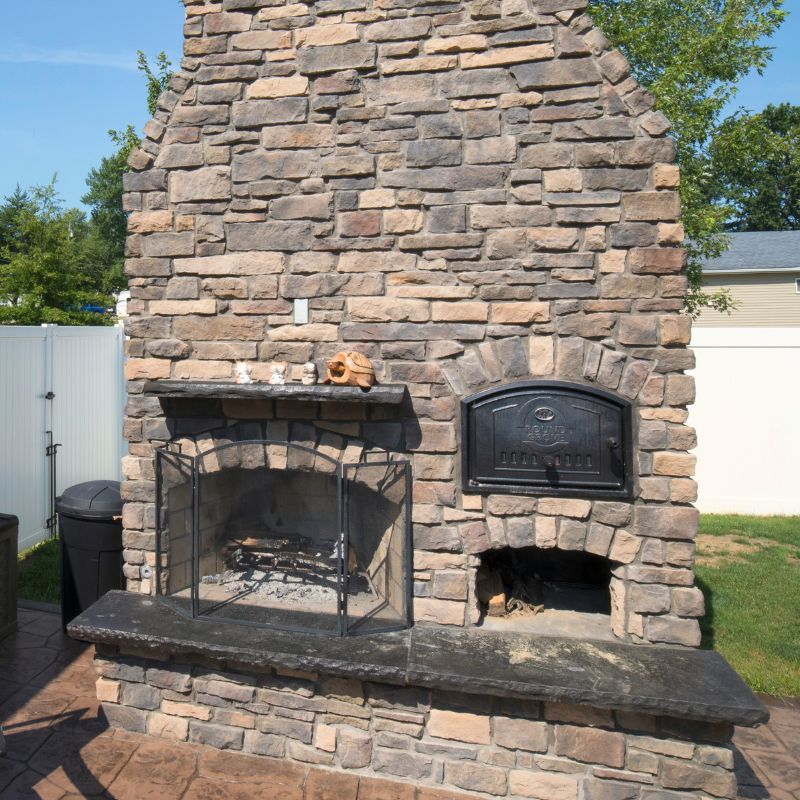 Round Grove Outdoor Brick Oven next to a Round Grove Fireplace