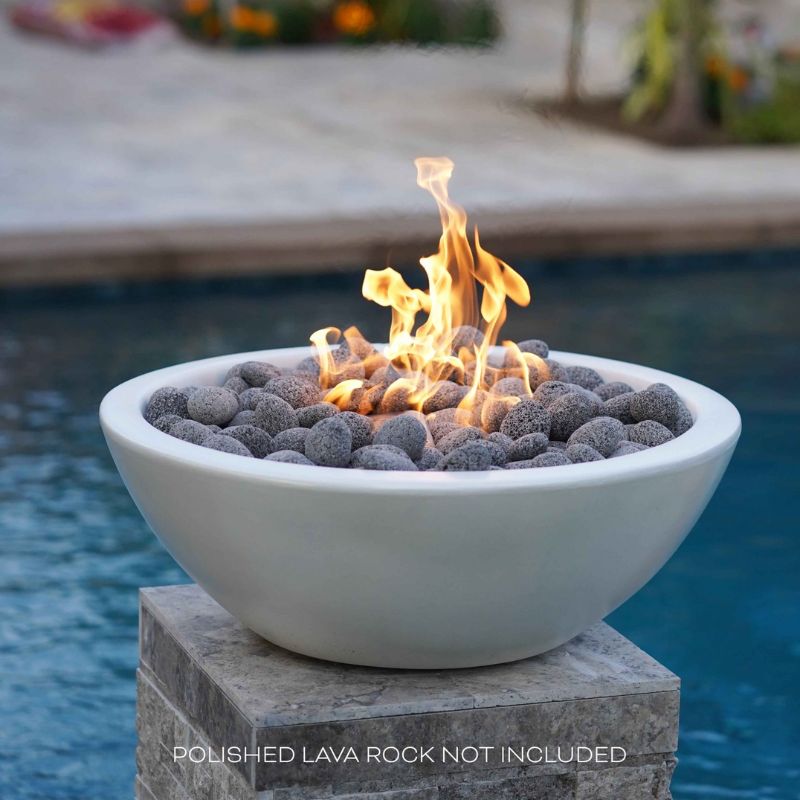 The Outdoor Plus Sedona Fire Bowl in White Limestone with Polished Lava Rock by the pool