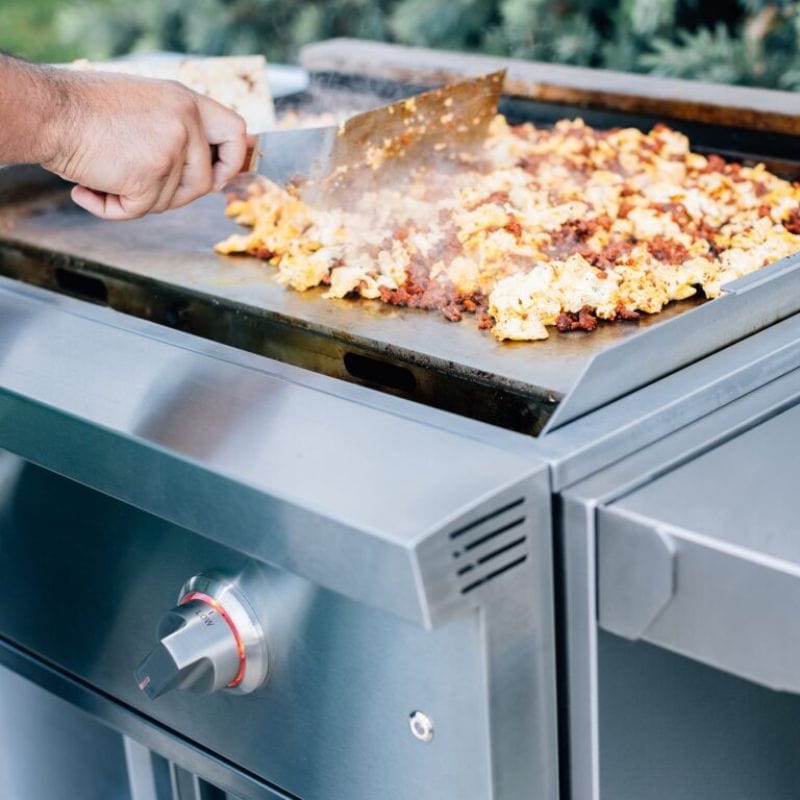 Man cooking meat and eggs on the Summerset 30inch Gas Griddle PRO