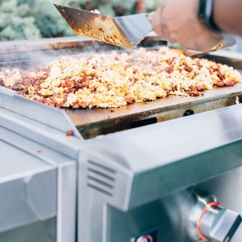 Man cooking on the Summerset Gas Griddle PRO
