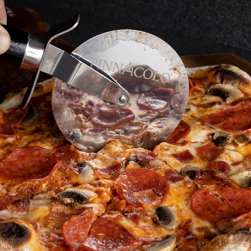 Close Up of the Pizza Cutter slicing through a pizza