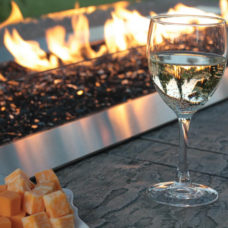 Cheese and wine sitting beside outdoor firepit by Carol Rose